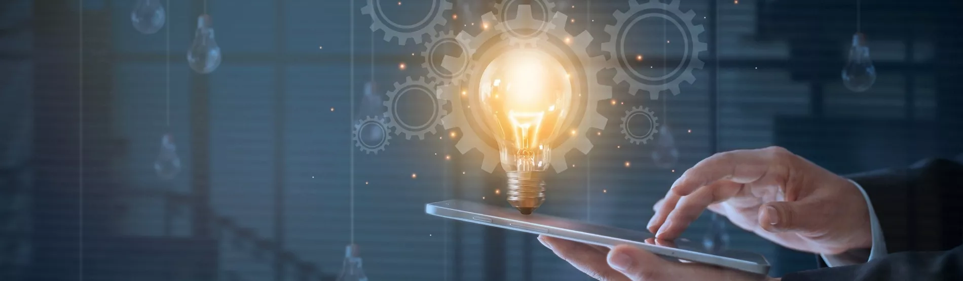 Une main en train de toucher une tablette et une ampoule illuminée